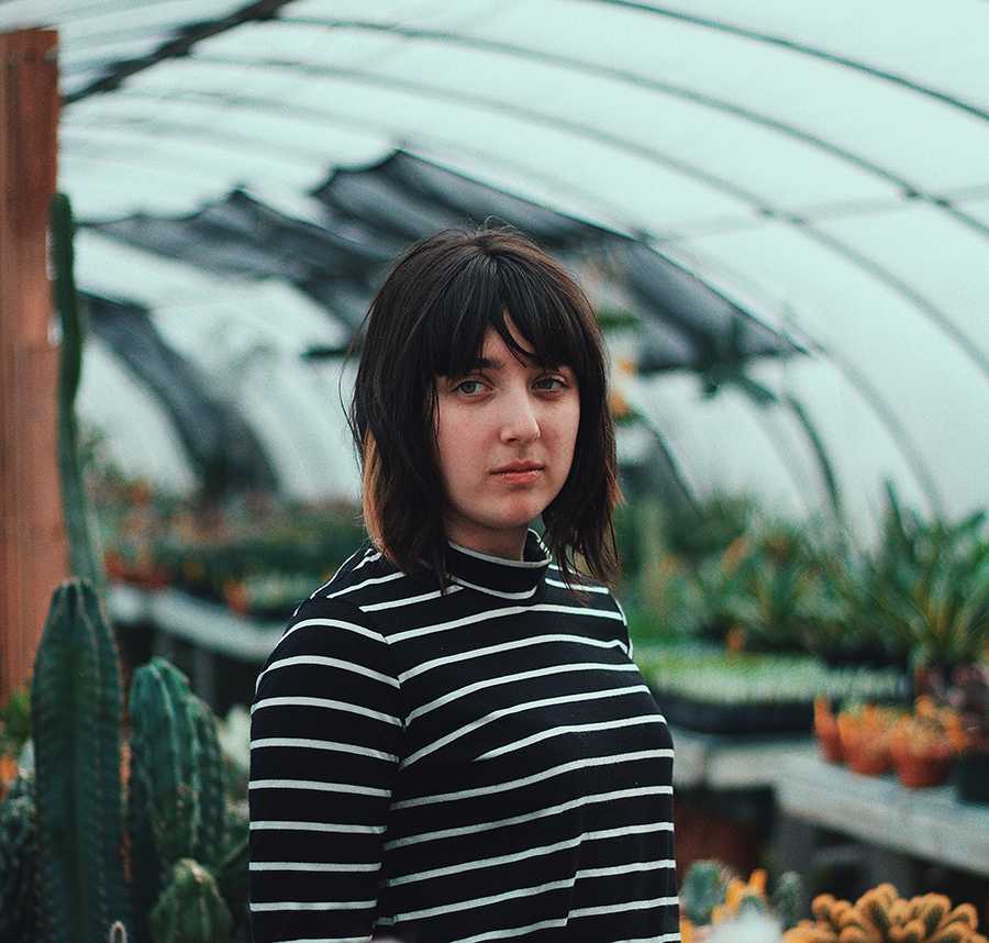A young white girl in a stripy shirt stares into the distance