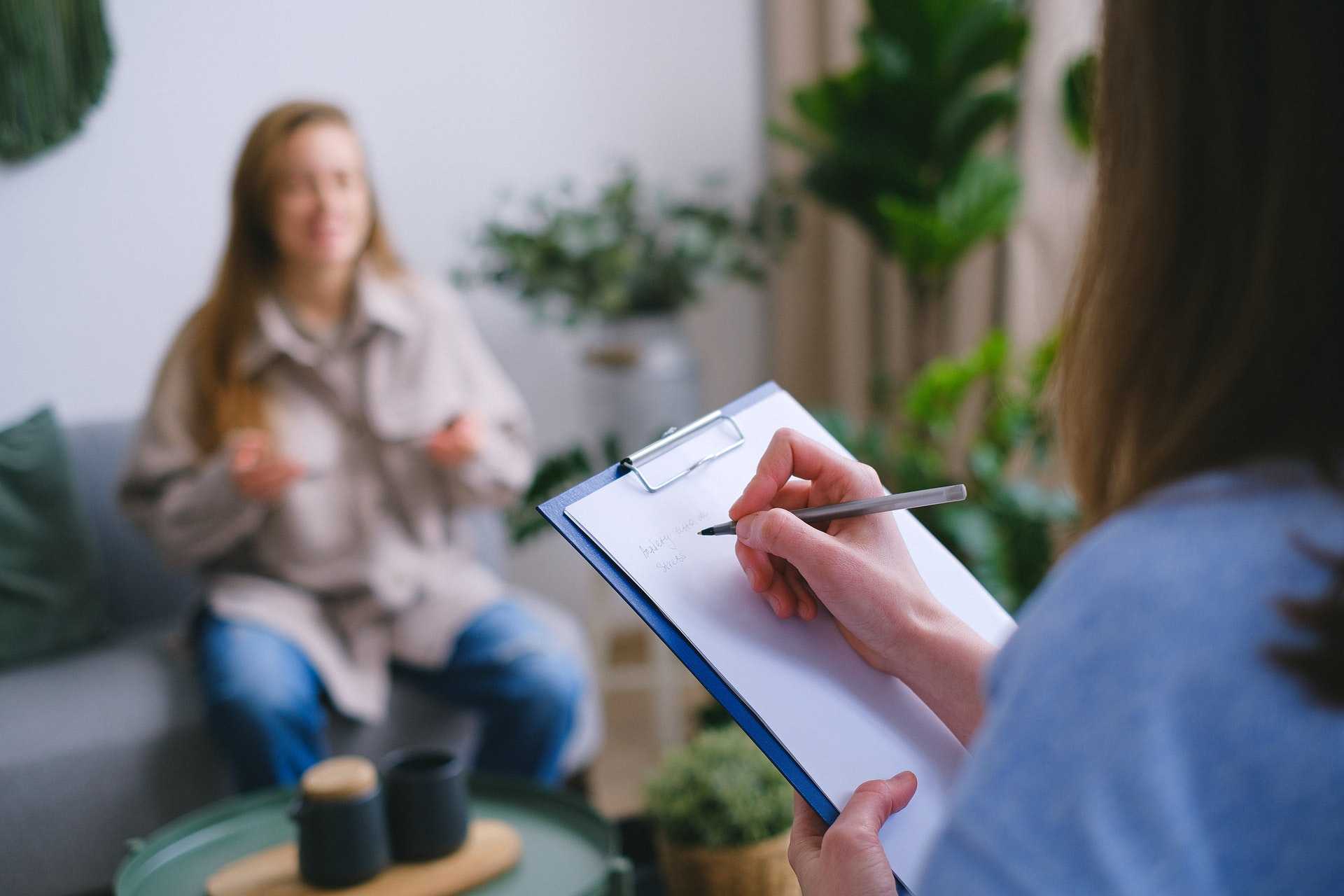 A psychologist taking notes notes during an appointment
