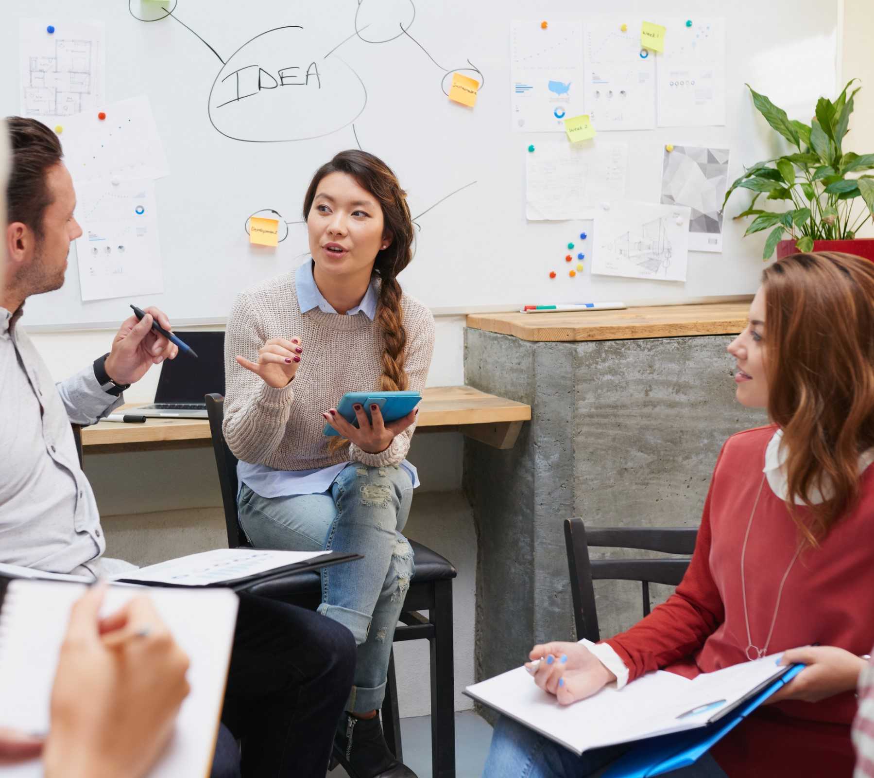 Young women speaking to a small circle of other people in a trainin session