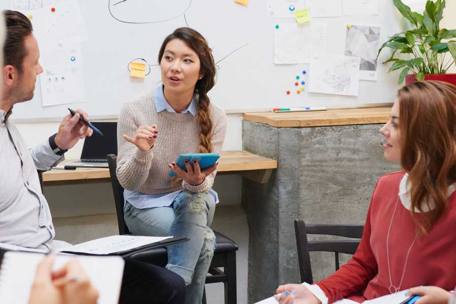 Young women speaking to a small circle of other people in a trainin session