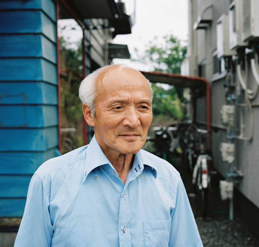 Elderly Asian man stares into the distance