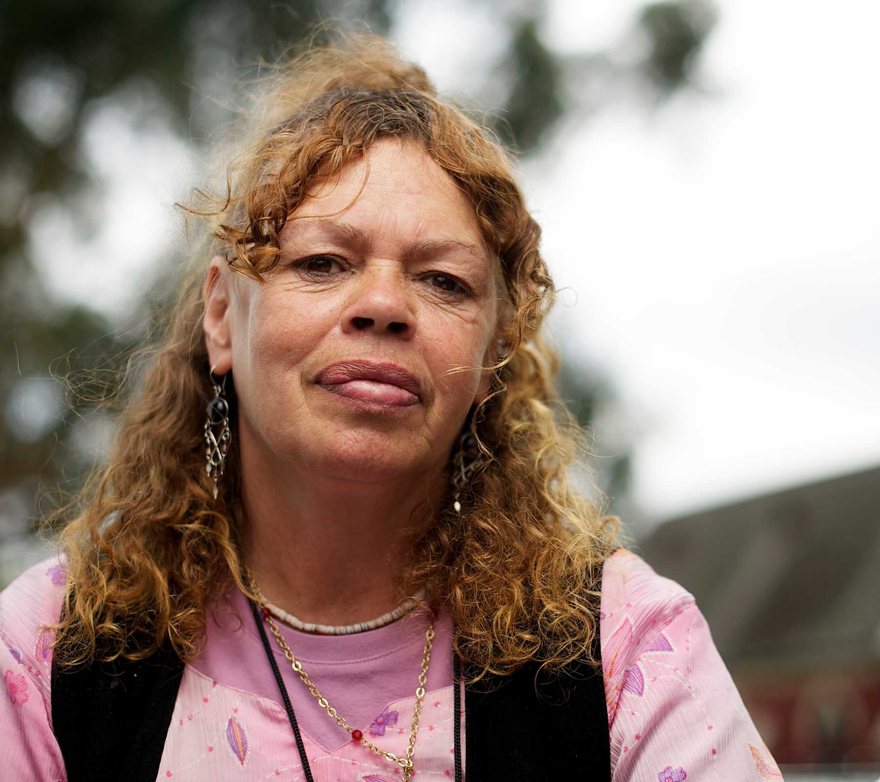 Aboriginal women looks at the camera in outside setting