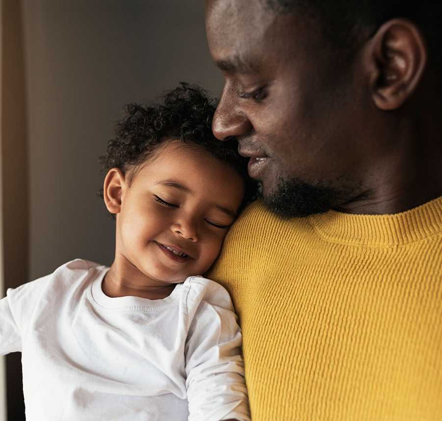 A man looks lovingly down at his young son.